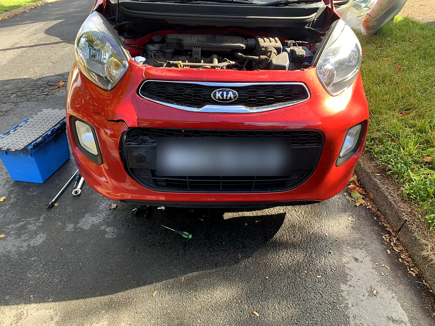 Kia Picanto with a damaged front bumper, repaired at the roadside.